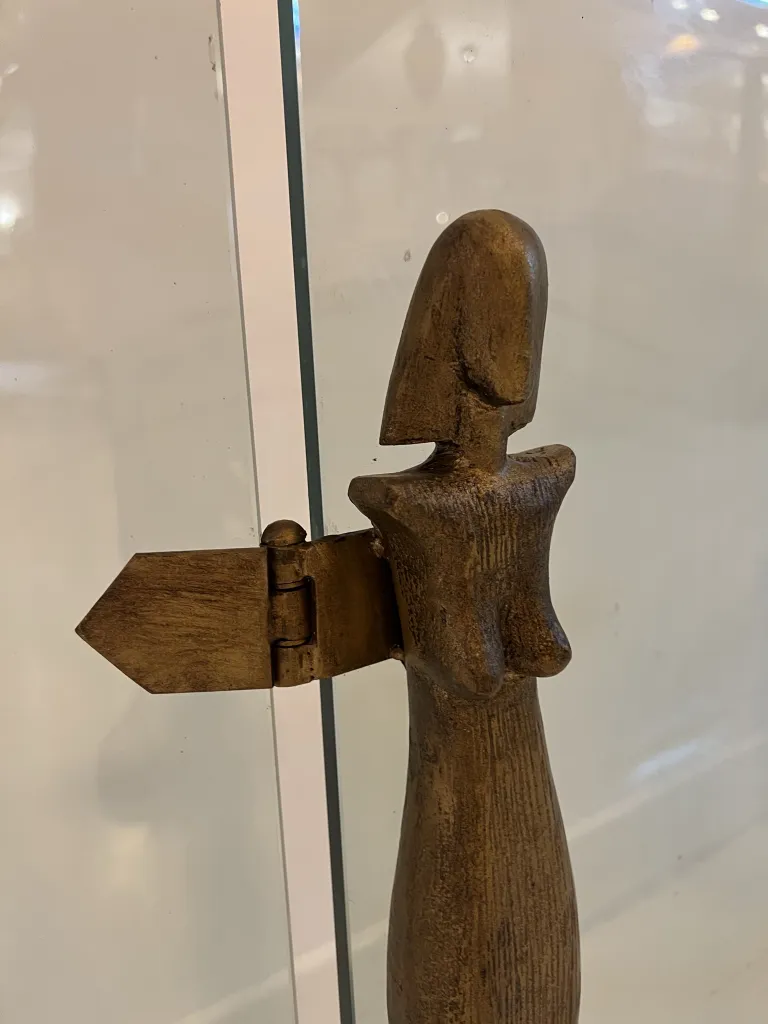 Frente da lareira antiga de Alberto Giacometti com formas estilizadas, exposto em um ambiente moderno.