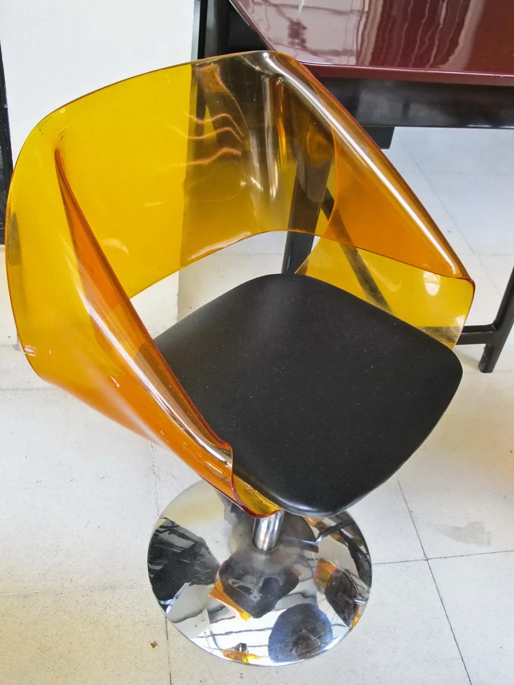 Quatre chaises anciennes au design translucide jaune, dans un environnement moderne.