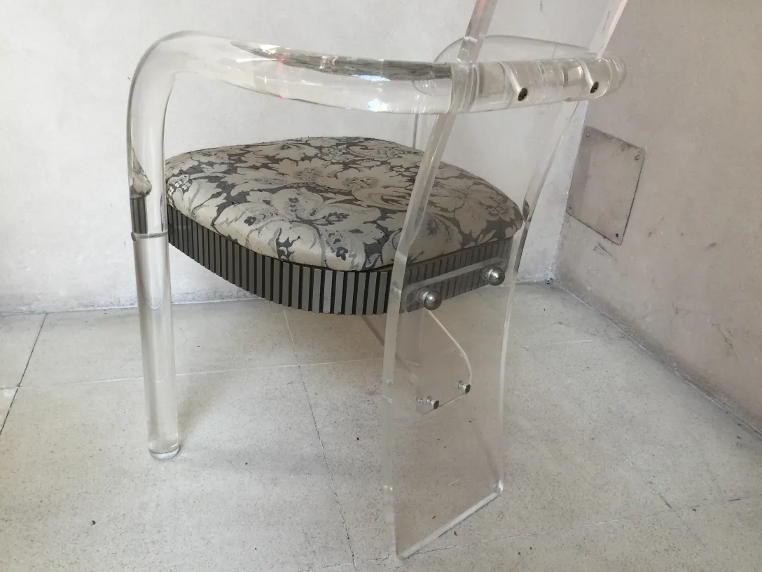 vista de silla antigua con cojín decorativo y fondo neutro