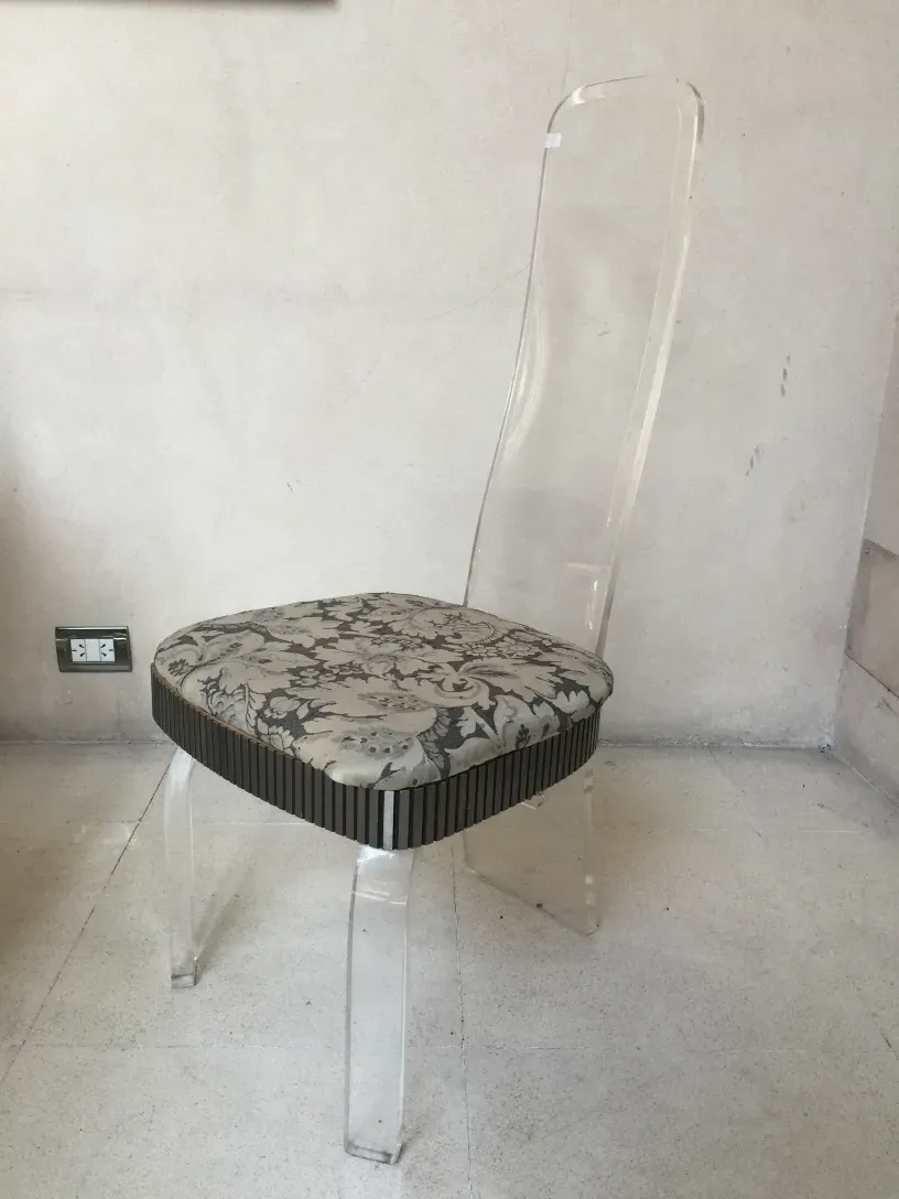 4 sedie e 2 poltrone antiche con sedili decorativi in un ambiente minimalista