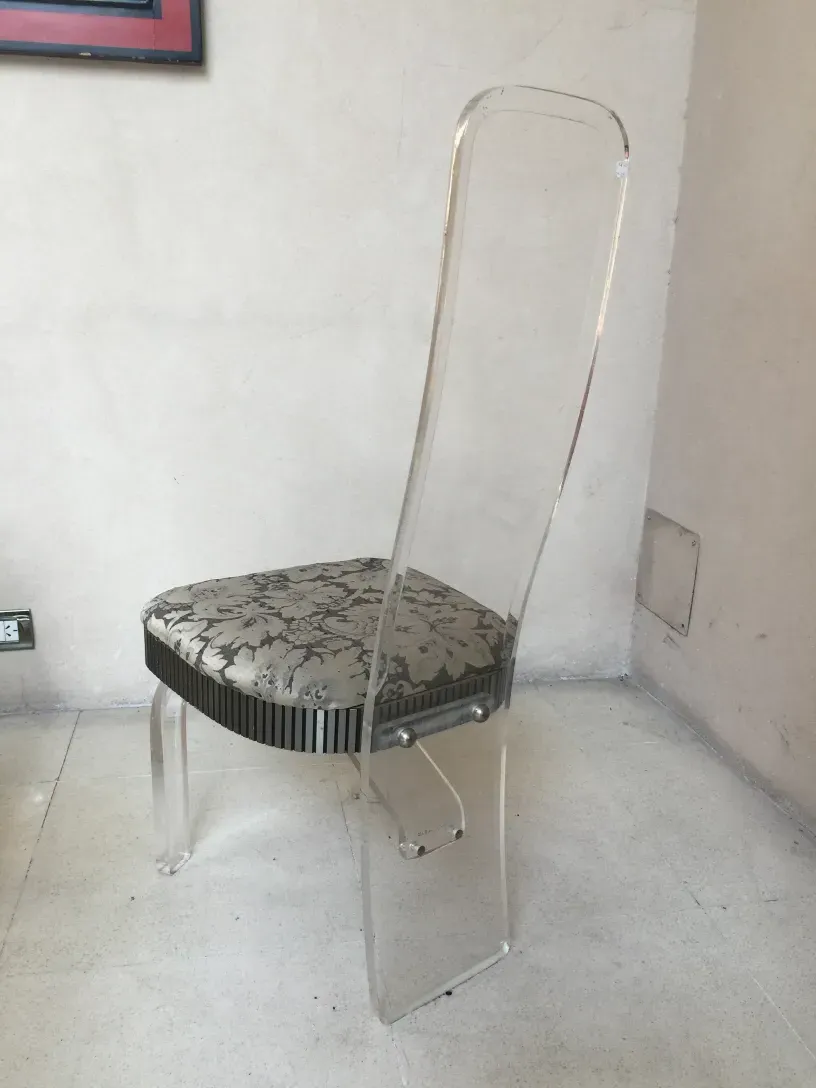 4 chaises et 2 fauteuils anciens avec design décoratif fleuri sur l'assise dans un cadre neutre.