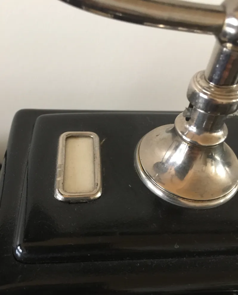 telefone antigo com base preta e detalhes brilhantes