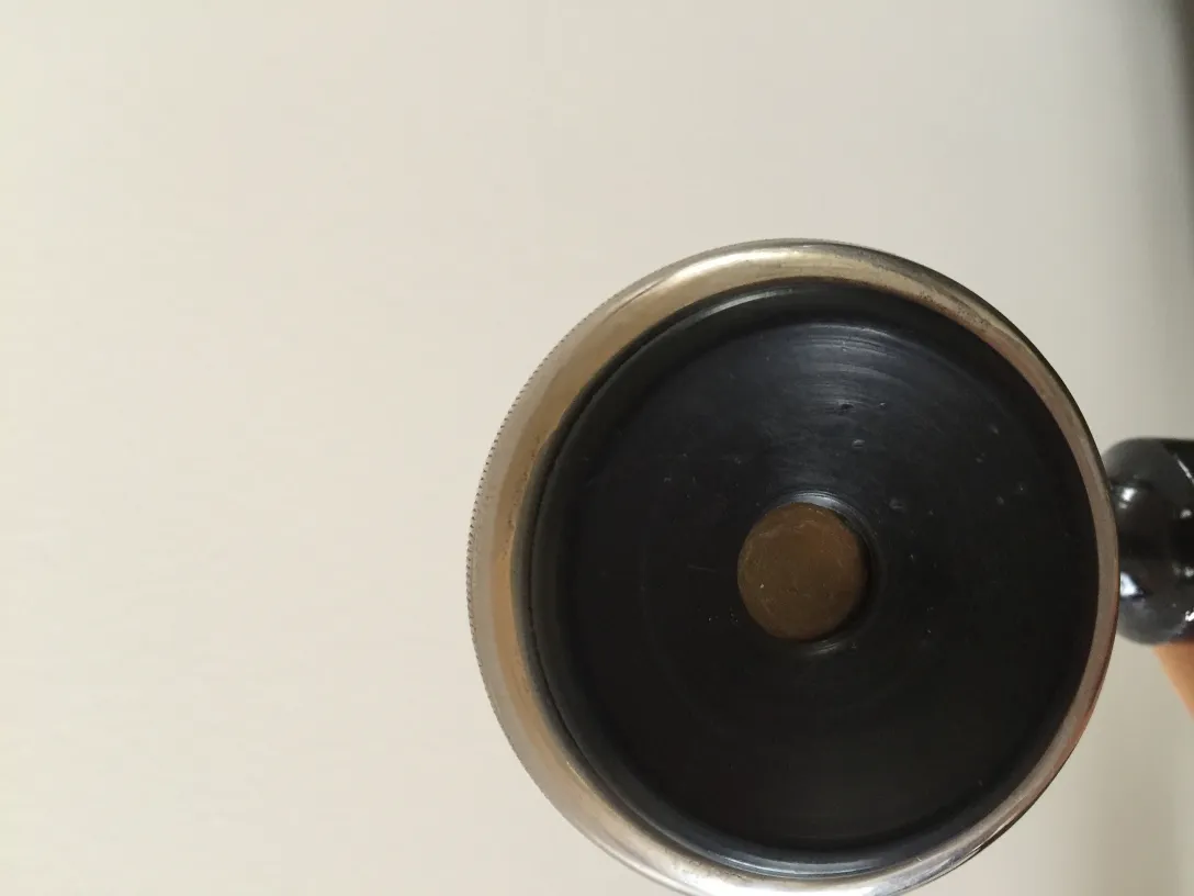 Unteransicht eines antiken Telefons mit runder Basis, sichtbare Details.