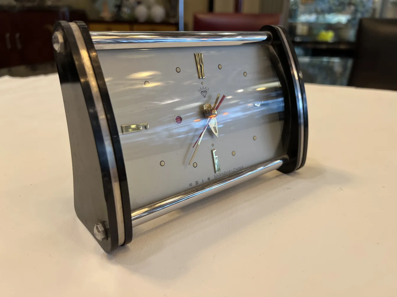 antike Tischuhr mit gebogenem Design und goldenen Zeigern