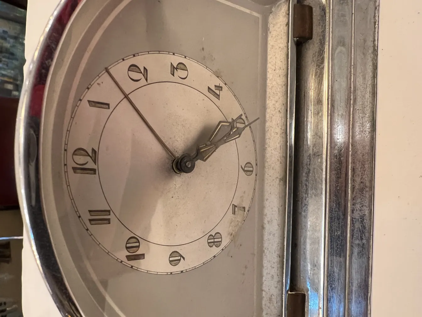 Antike Wanduhr mit römischen Ziffern und klassischen Zeigern in einer gemütlichen Umgebung.