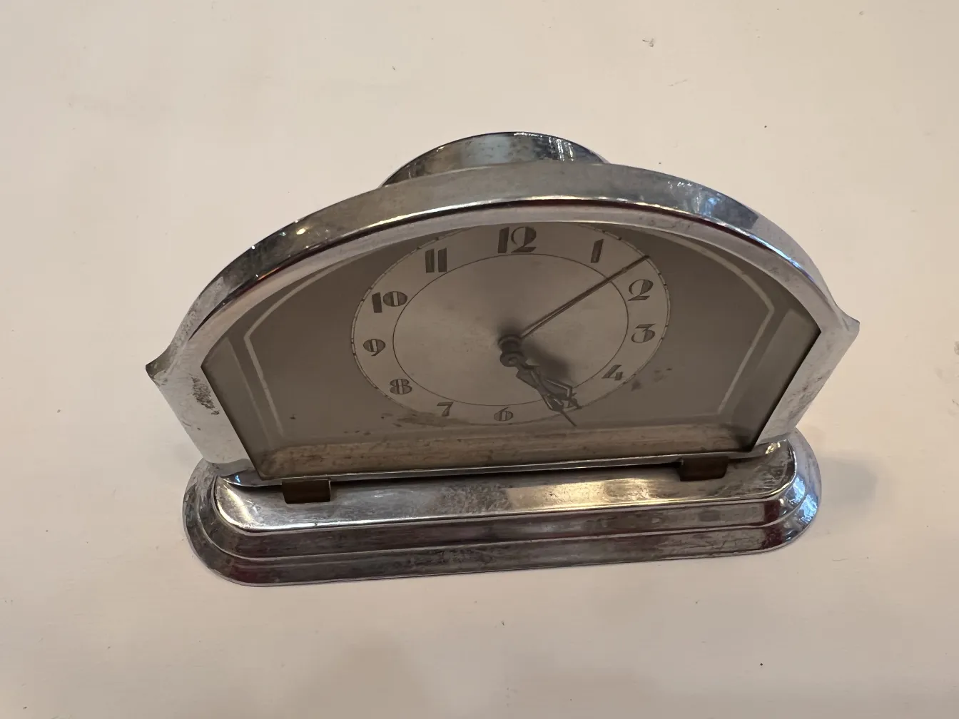 relógio de mesa antigo com design clássico, marcadores de hora e ponteiros visíveis