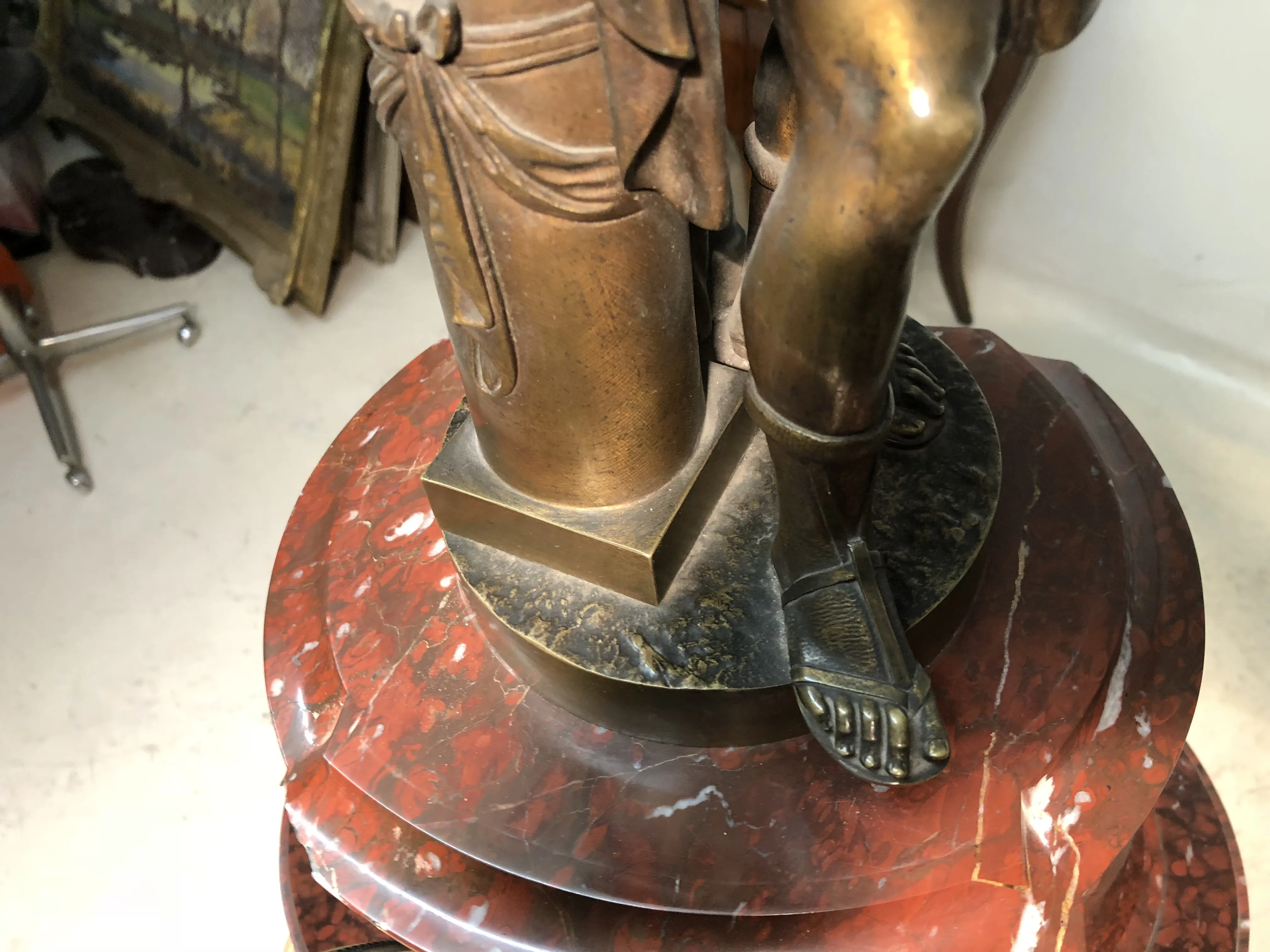 antique clock carved with decorative details on a round pedestal