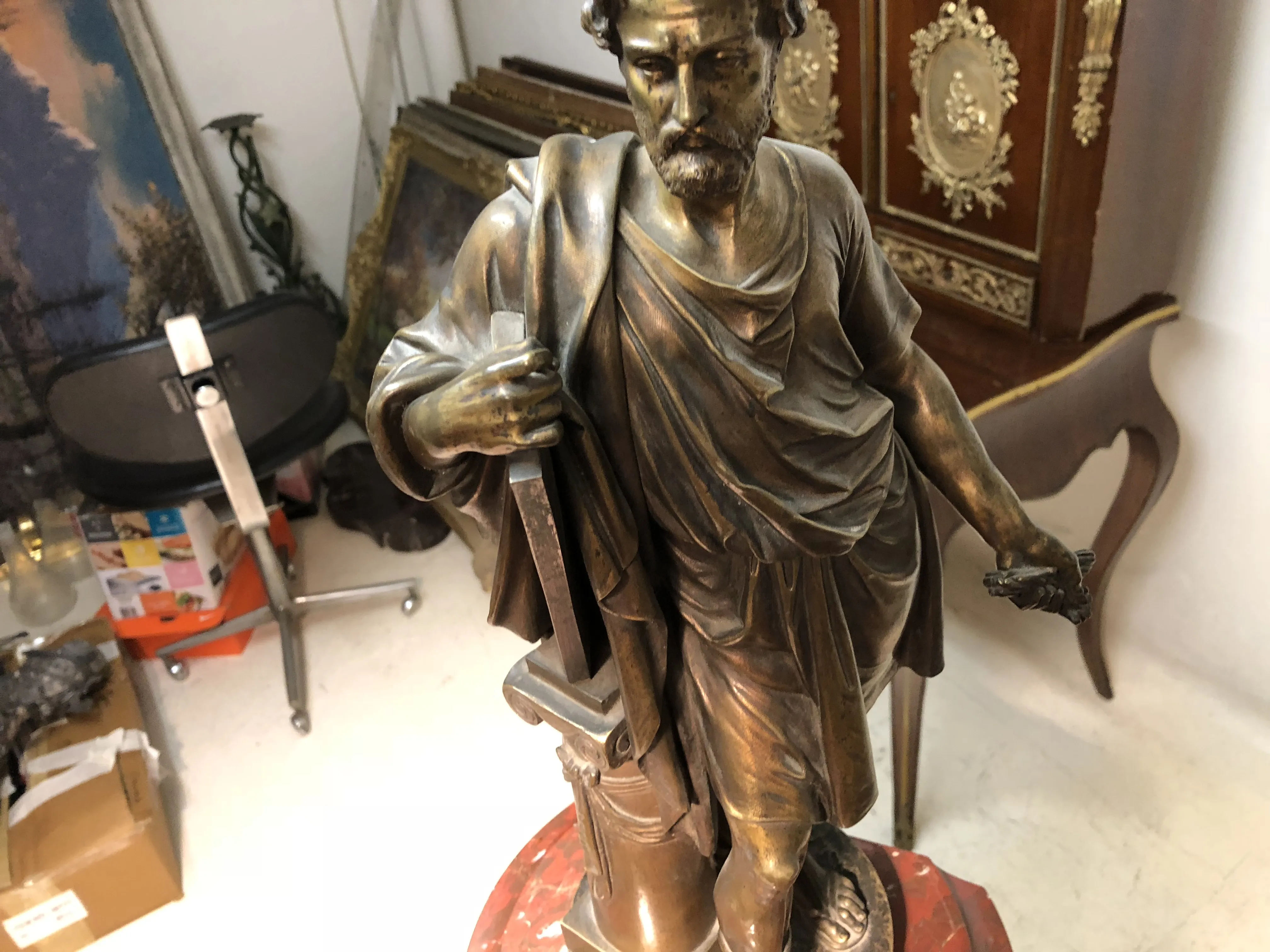 relógio antigo decorativo com uma figura masculina segurando um objeto, fundo de antiguidades