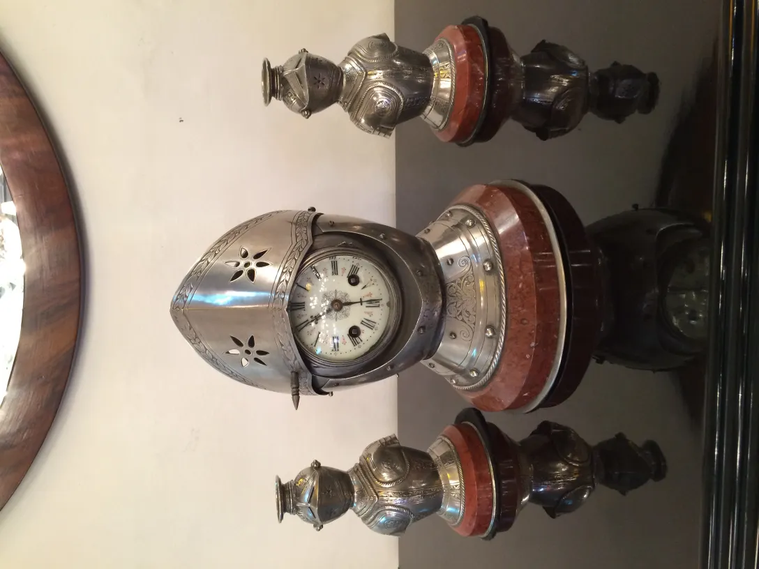 Horloge ancienne avec des candelabres décoratifs sur la table.