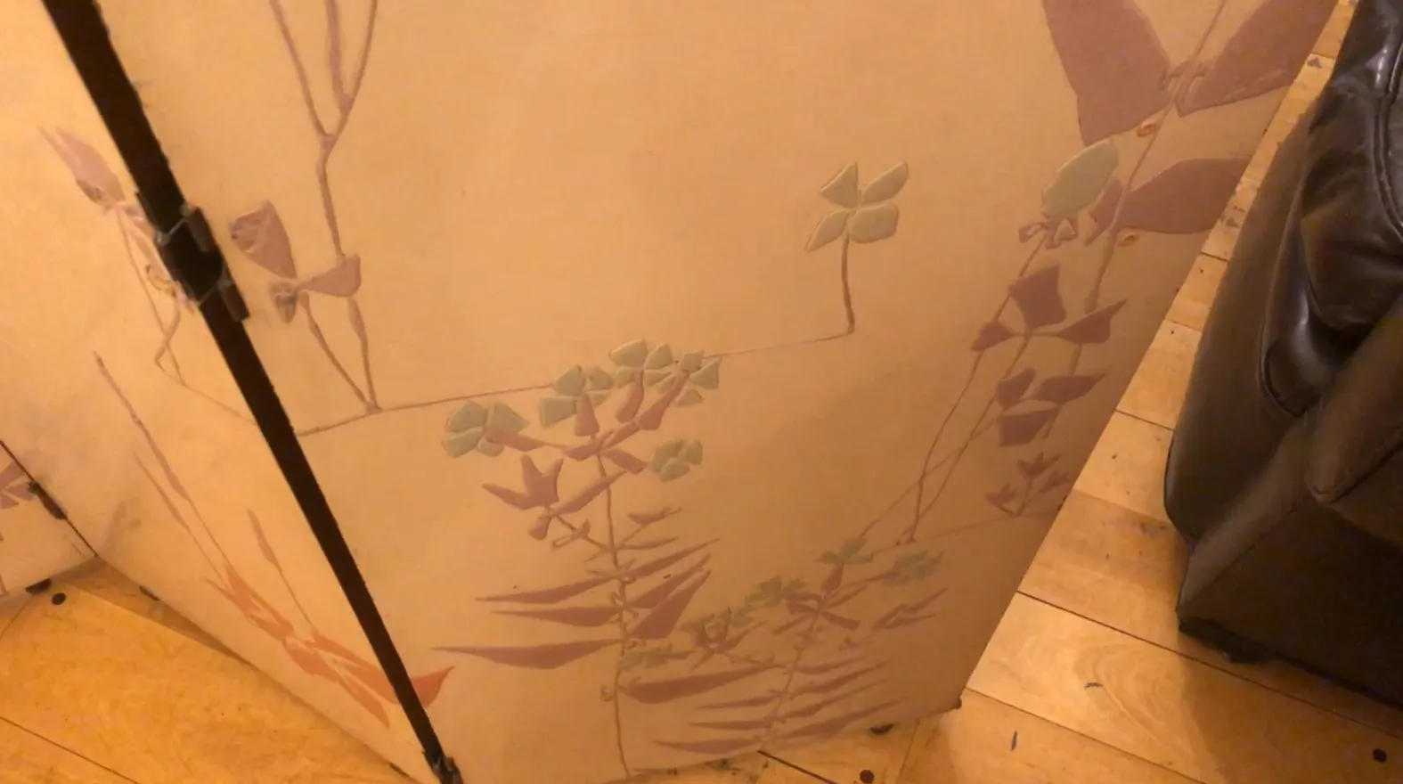 biombo antiguo con diseño botánico en un ambiente acogedor