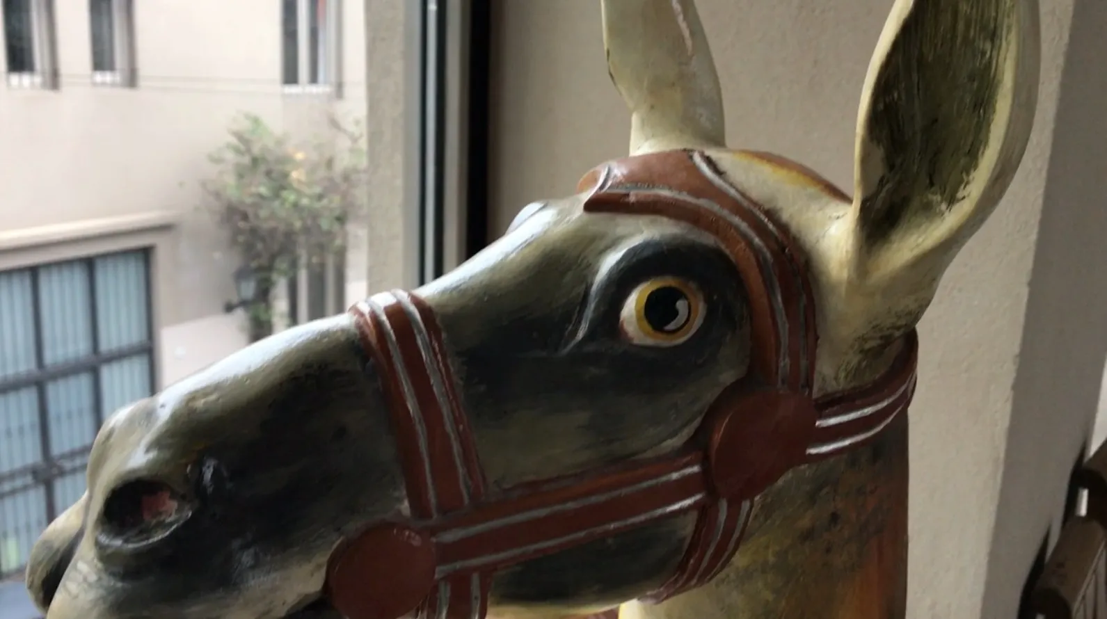 Antique llama sculpture with colorful and expressive details.