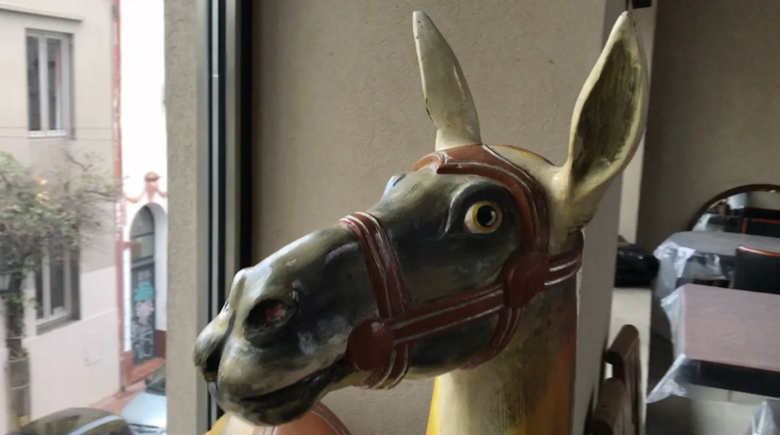 Escultura de lhama antiga em uma vitrine, detalhes vibrantes