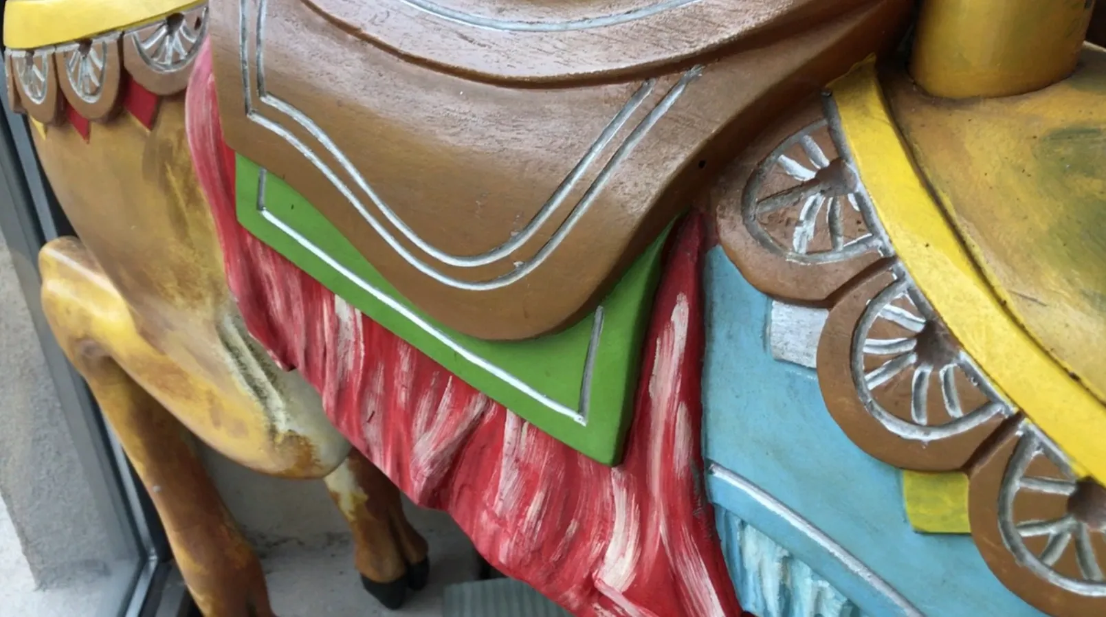 Figura antiga de lhama com cores vibrantes e detalhes decorativos.