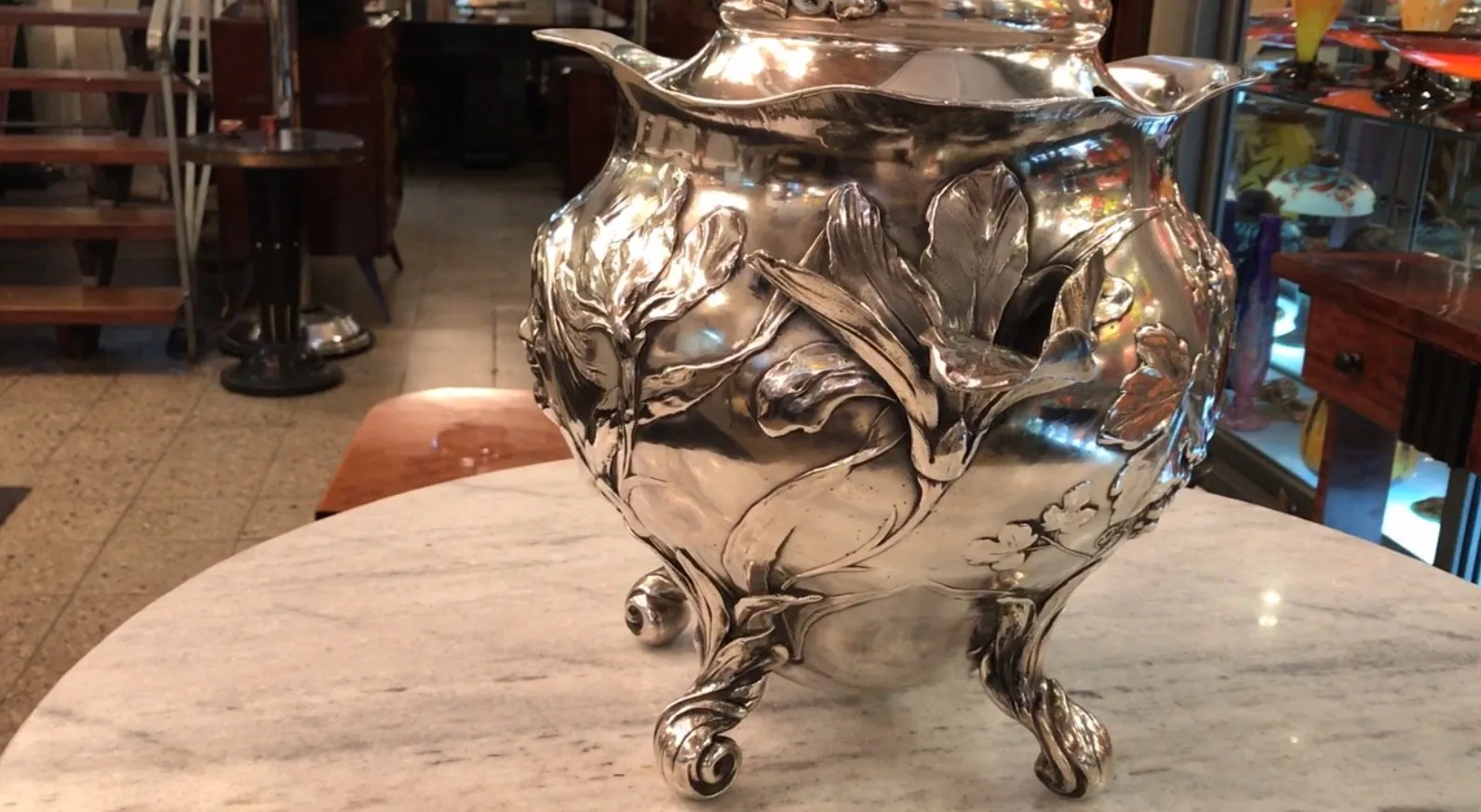 Antique WMF punch bowl with floral decoration, cozy setting.