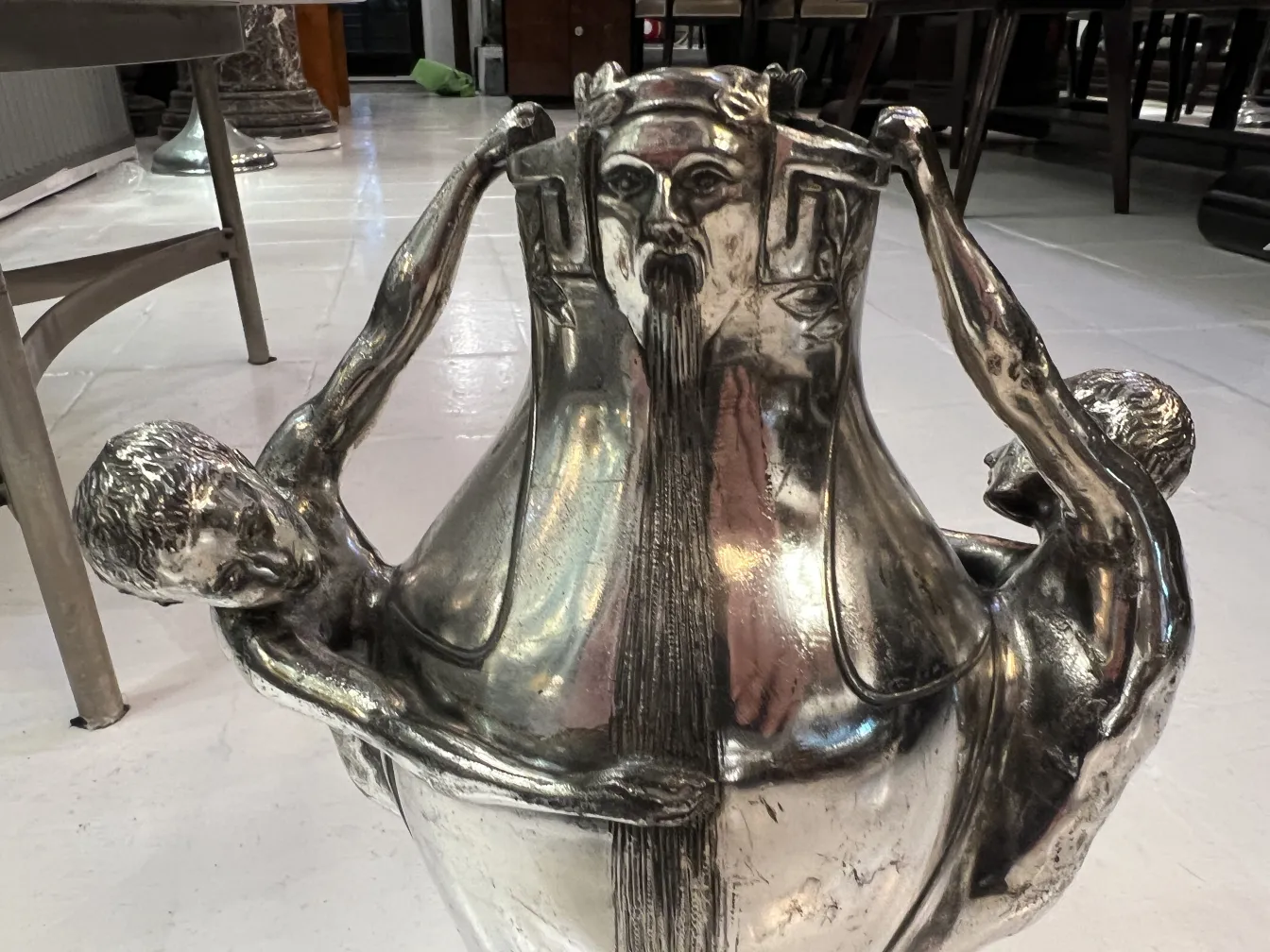 vaso antigo com figuras em relevo e detalhes artísticos, fundo neutro