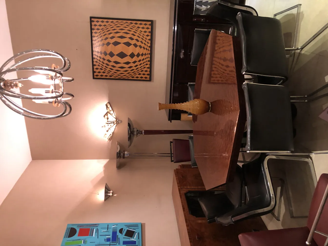 elegantly shaped antique vase on table with chairs