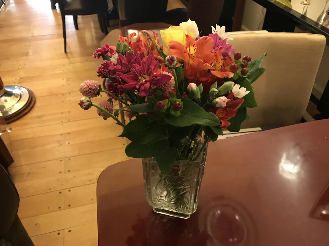 vase antico con un mazzo di fiori vivaci su un tavolo