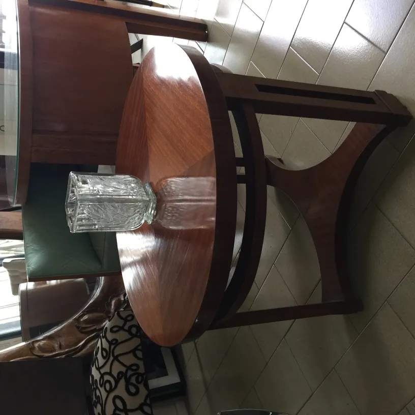 florero antiguo en una mesa con sillas de fondo