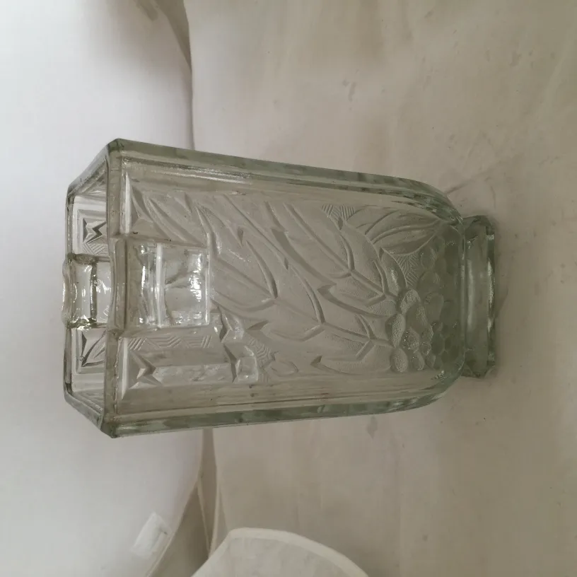 antique glass vase with leaf design, in a light setting