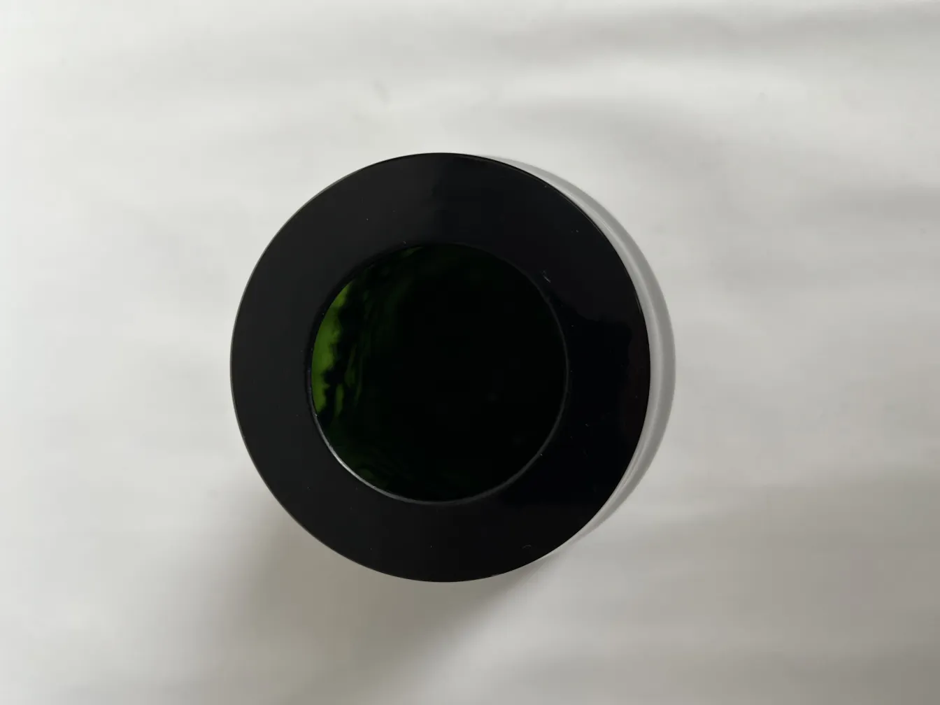 antique vase with a black rim and green interior