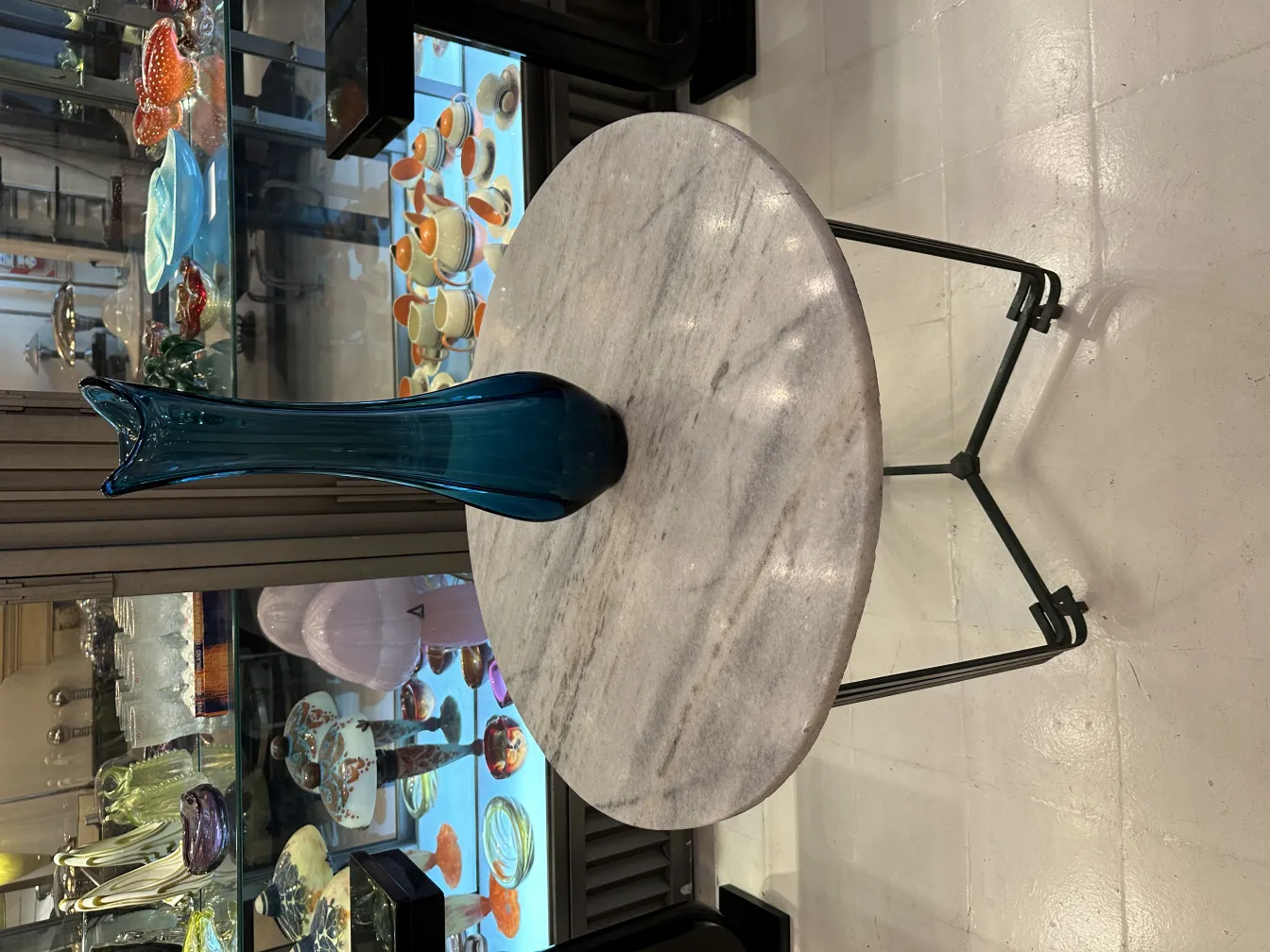 florero azul en una mesa con decoraciones antiguas