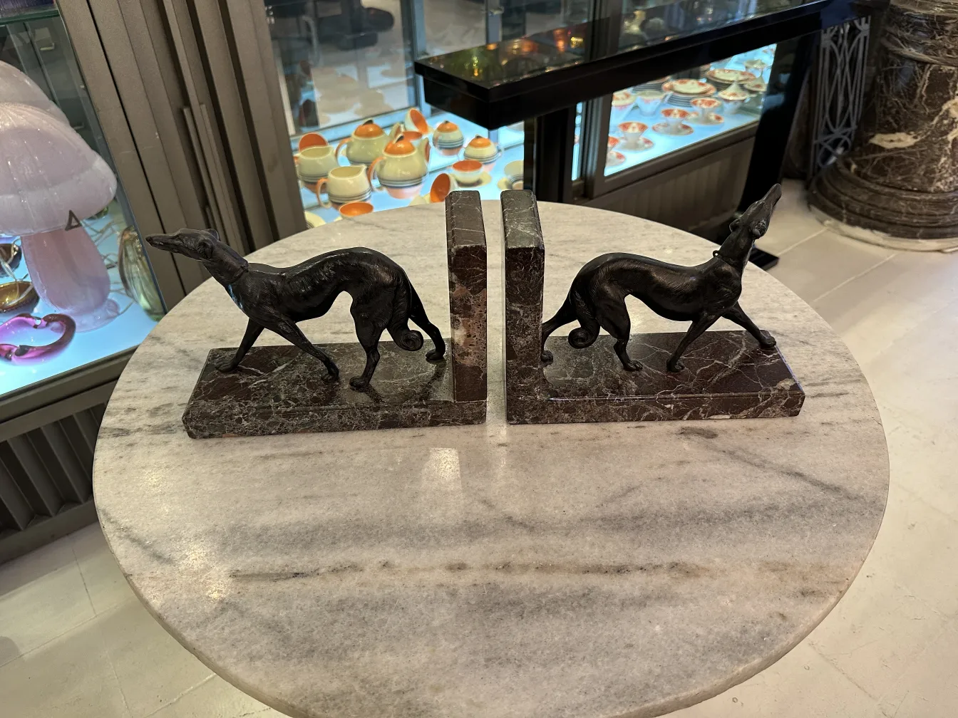 Antike Buchstützen in Form von Hunden auf einer Marmoroberfläche.