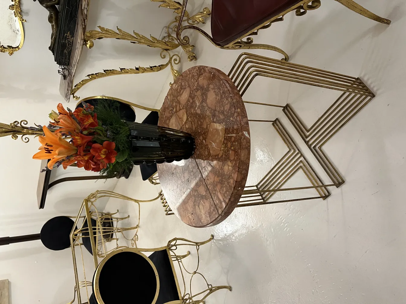 vase antico con gigli arancioni e fiori assortiti su un tavolo