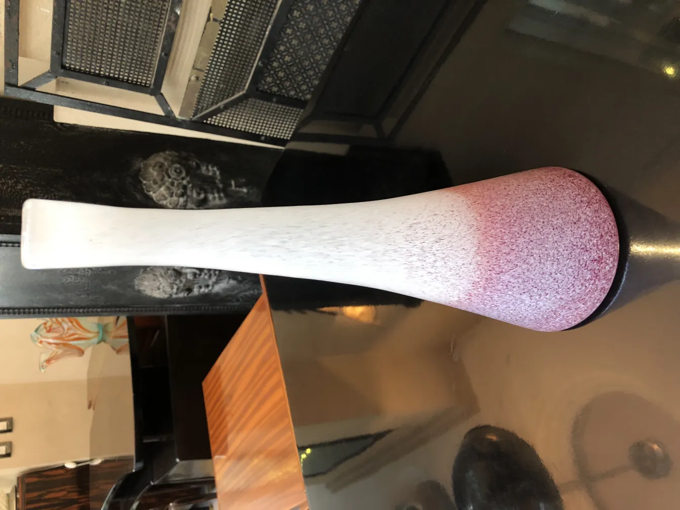 florero antigüedad con diseño en gradiente y base negra, decorando el ambiente