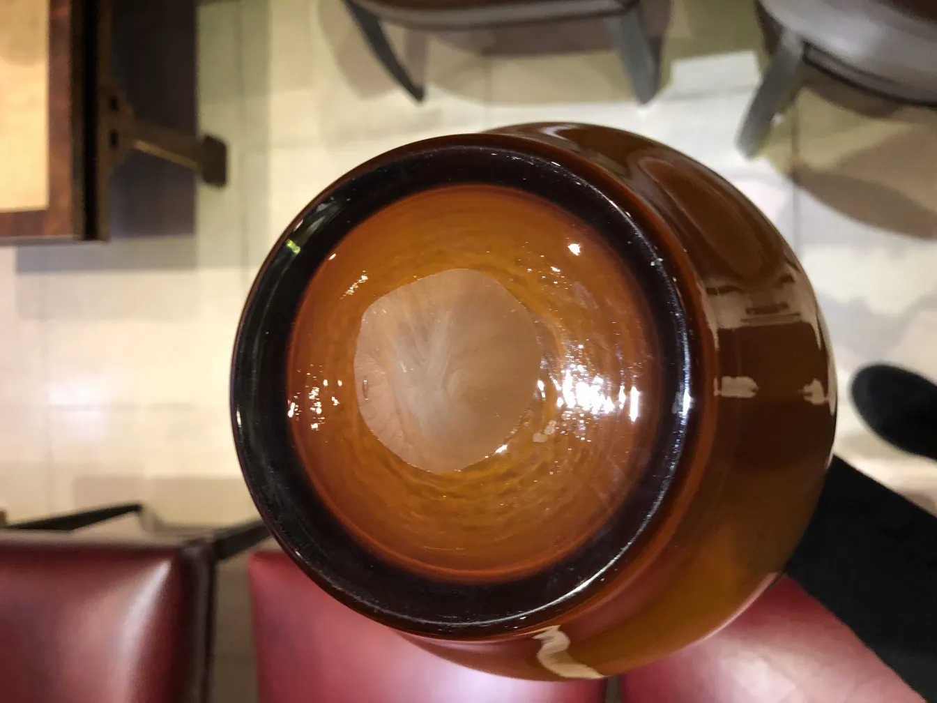 vaso de flores antigo na cor âmbar visto de cima, fundo com móveis