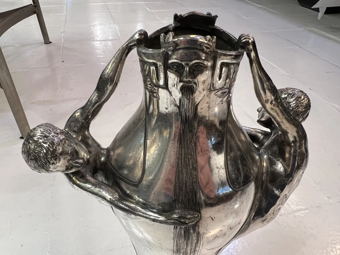 antique vase with sculptural details of human figures