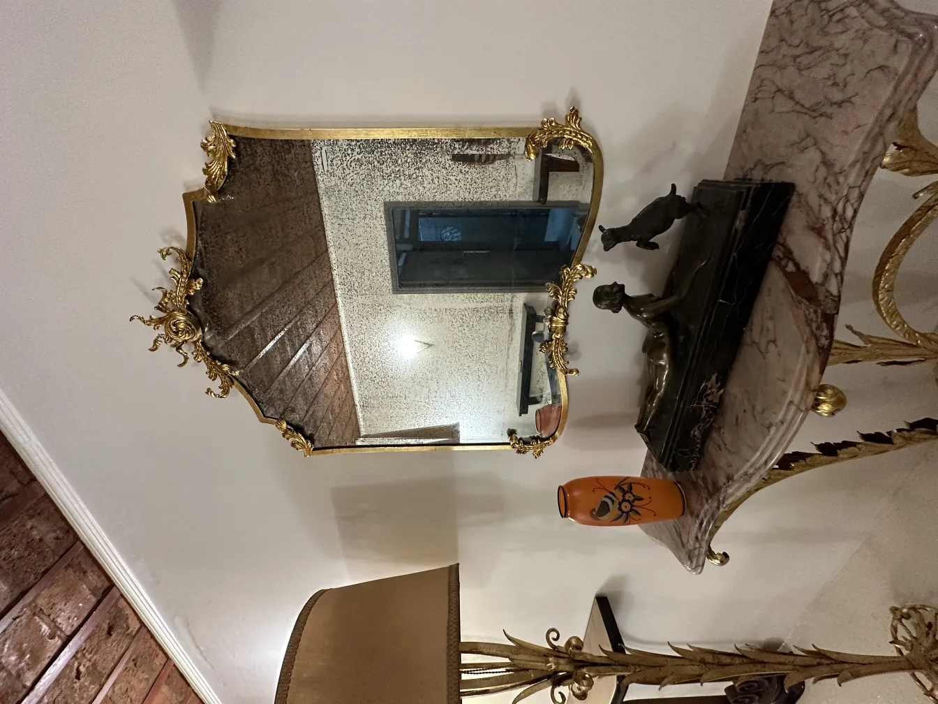 Vase ancien décoratif sur une table avec un miroir.