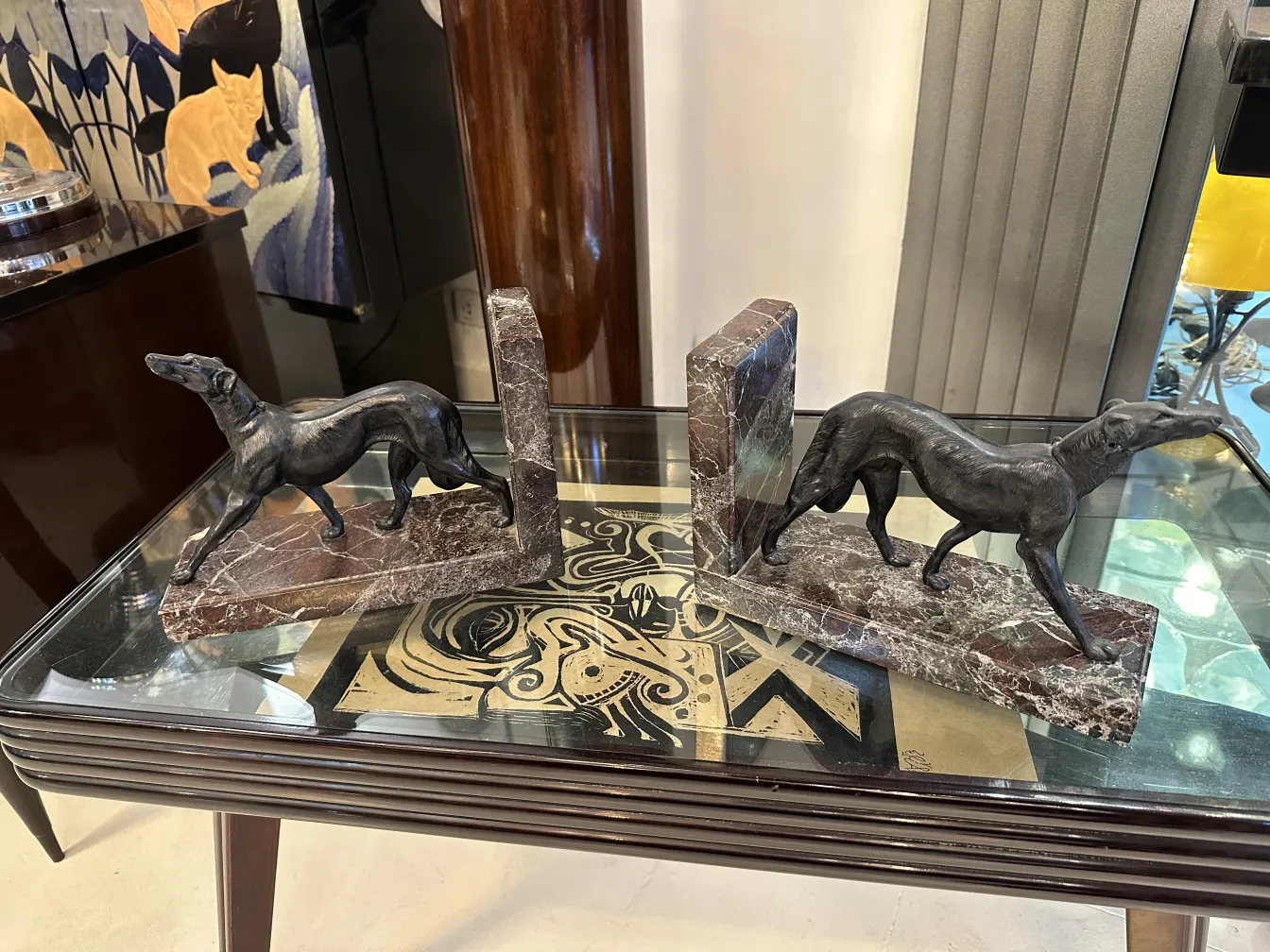 Dog figurines as bookends on a glass table.