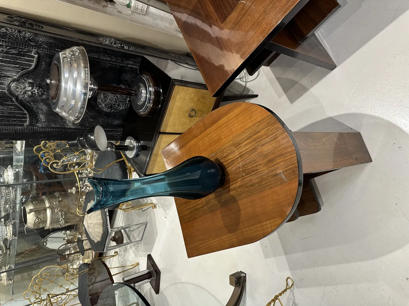 vase antico in vetro blu su un tavolo di legno, circondato da oggetti d'antiquariato.