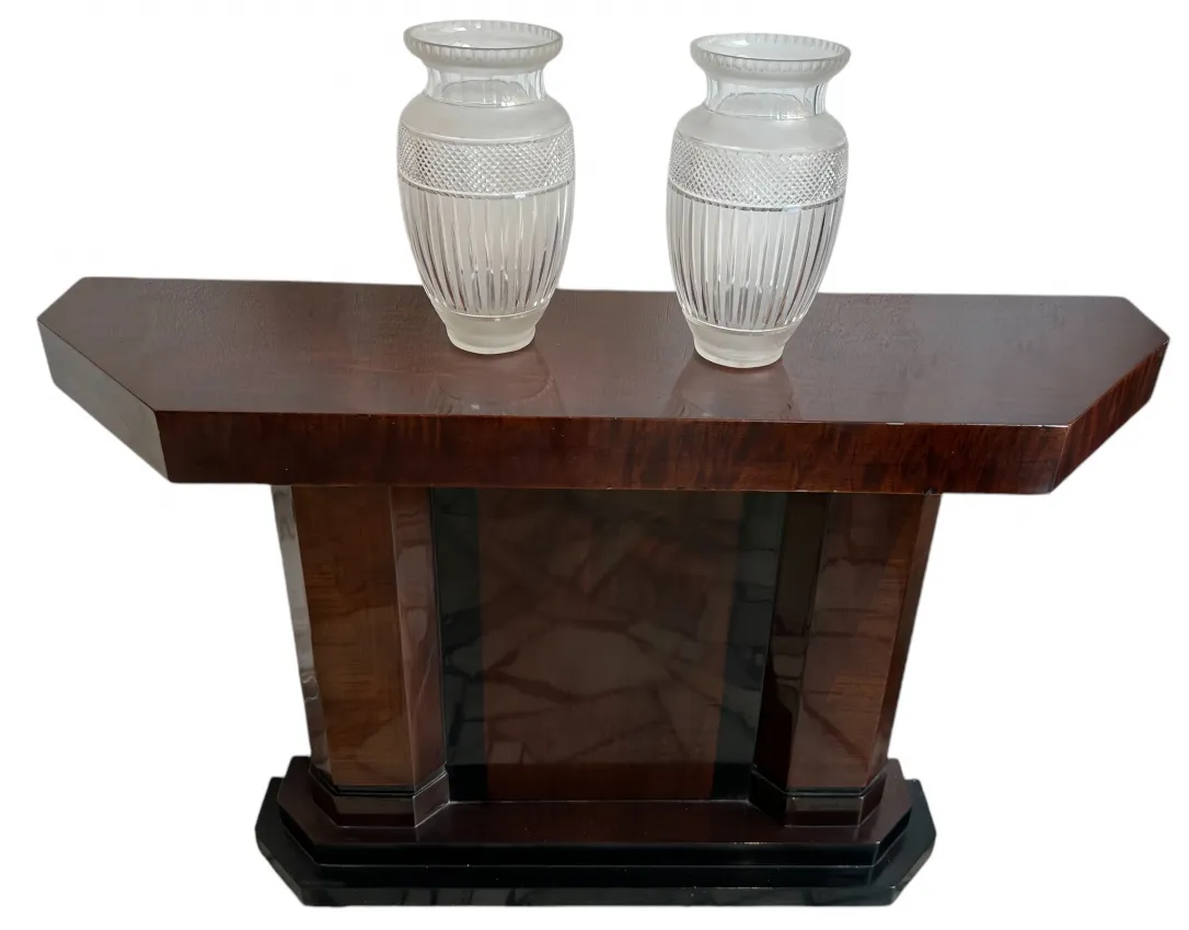 Dois vasos antigos de vidro em uma mesa de madeira escura.