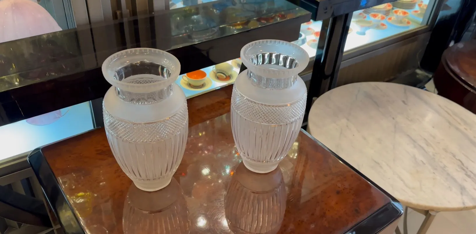 Deux vases anciens décoratifs sur une table brillante.