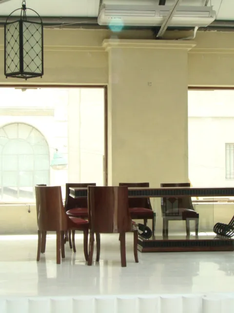 Tavolo da pranzo antico con sedie in un ambiente moderno e spazioso.