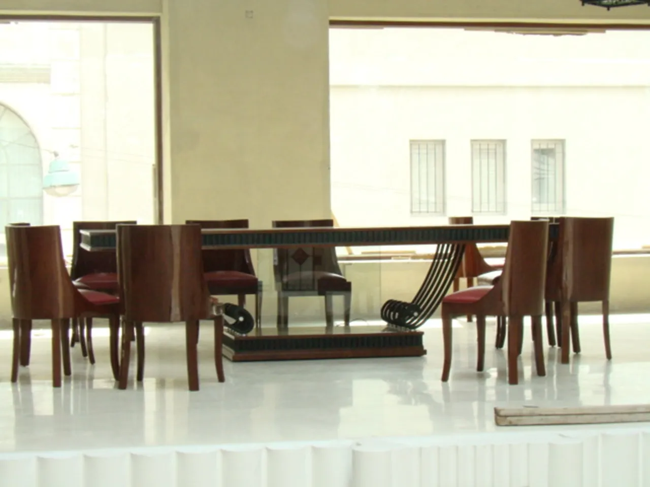 Mesa de comedor antigua de diseño Art Deco con sillas, ambiente luminoso.