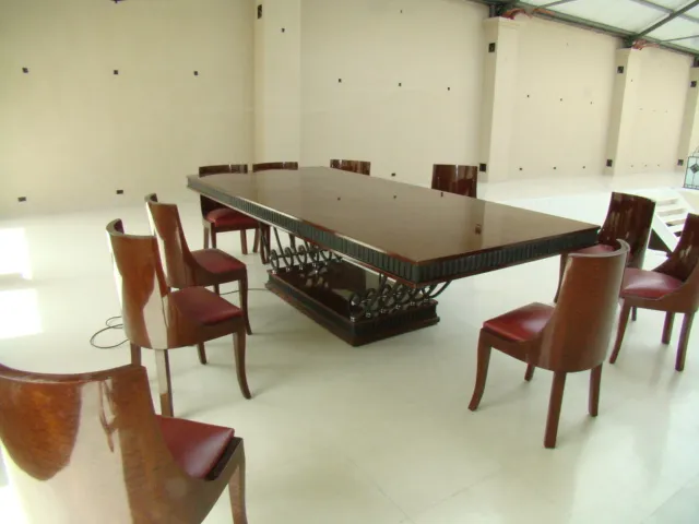 Mesa de comedor antigua Art Deco con sillas alrededor, ambiente elegante.