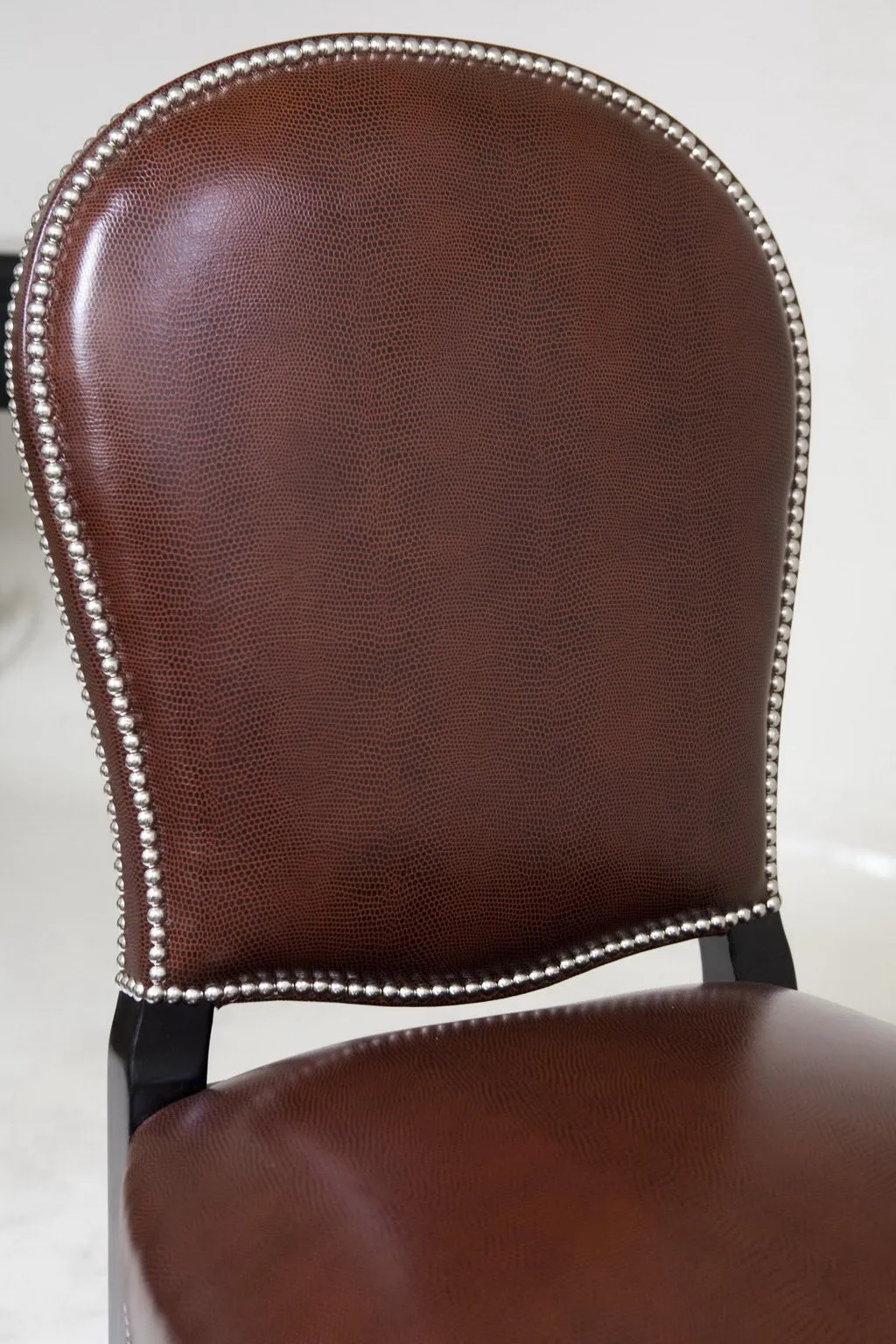 View of an antique art deco chair featuring a rounded back and silver embellishments