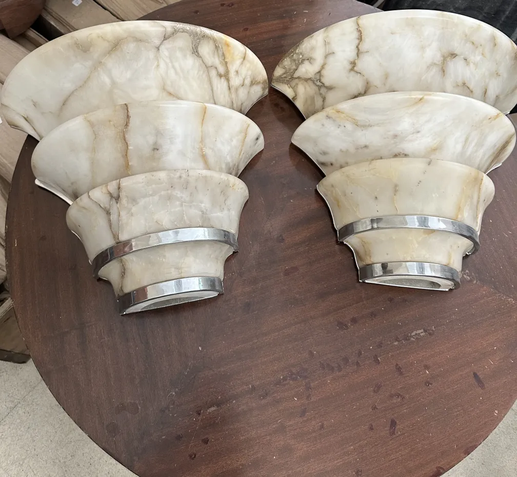 Antike Wandleuchter auf einem Holztisch, gebogene Form.