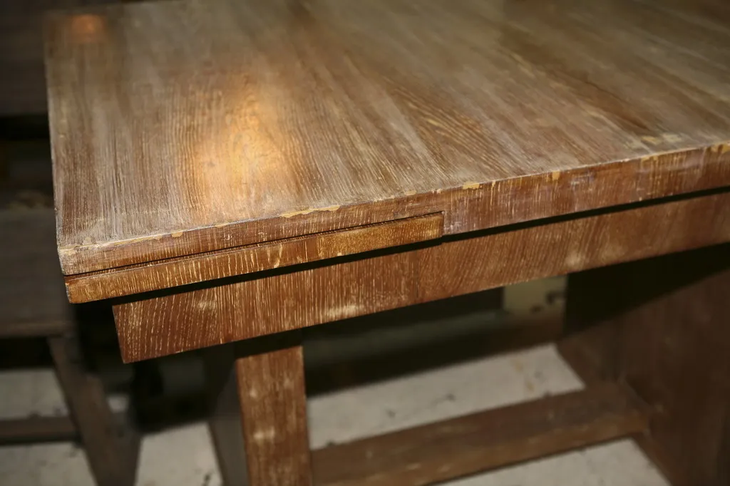 Description d'une table à manger antique avec une finition claire, conçue par Jean Michel Frank, idéale pour 6 ou 4 personnes, dans un cadre accueillant.