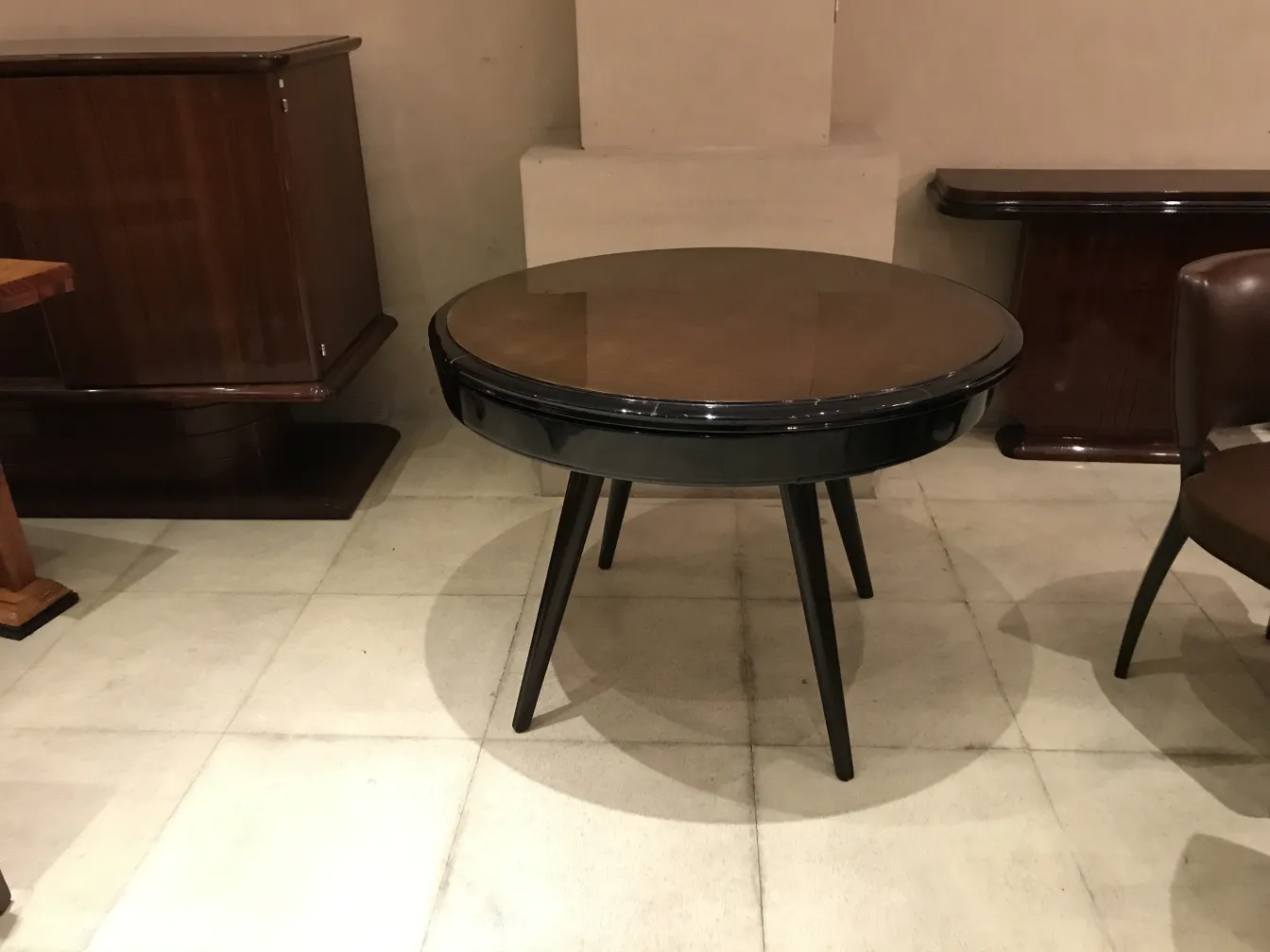 Mesa de jantar antiga redonda para quatro pessoas em um ambiente elegante.