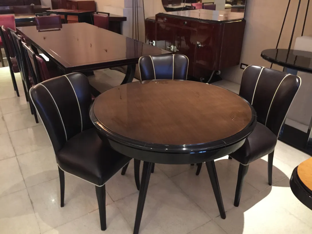 Mesa de jantar antiga com quatro cadeiras em um ambiente elegante.