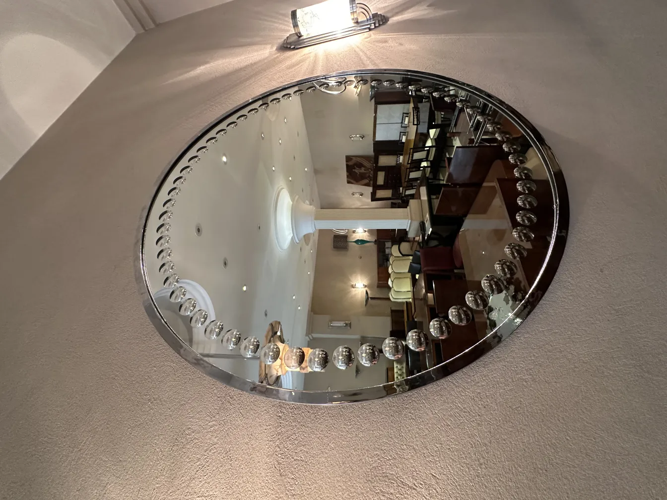 antique art deco mirror with shiny embellishments on the wall