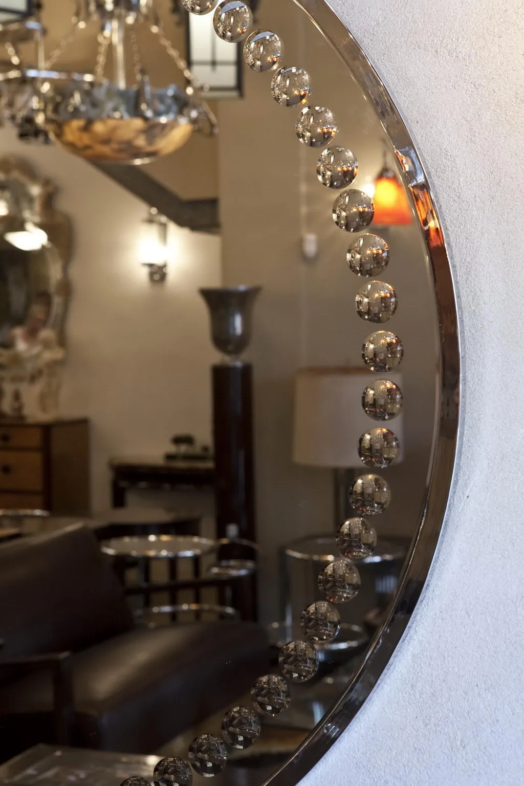 espelho antigo art deco com formato redondo e detalhes decorativos, em um ambiente elegante