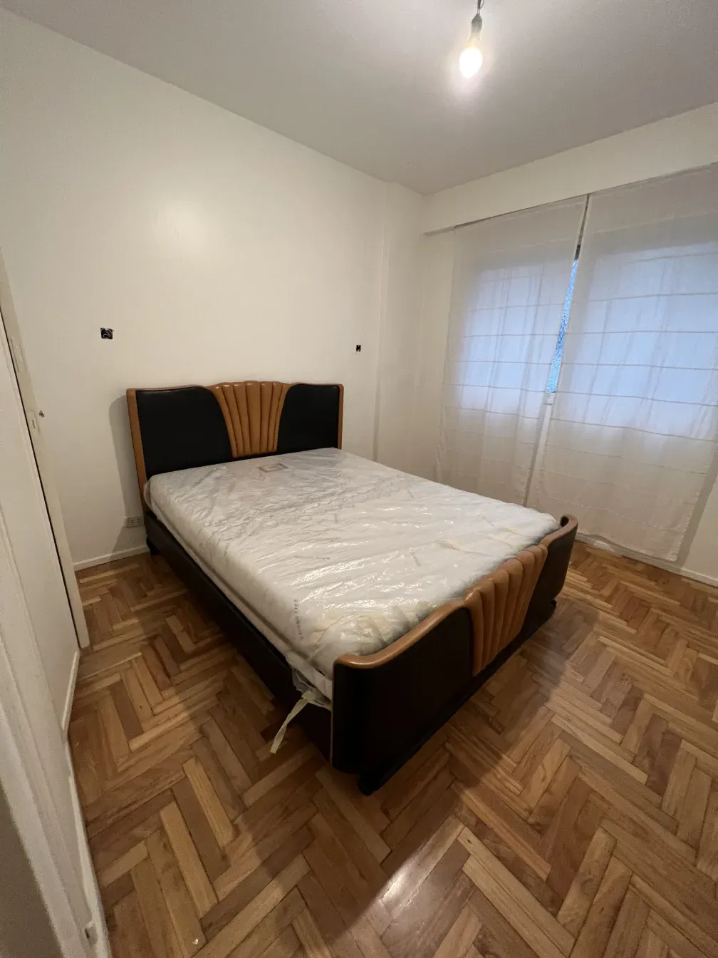 Antikes Bett in einem Raum mit natürlichem Licht und Holzböden.