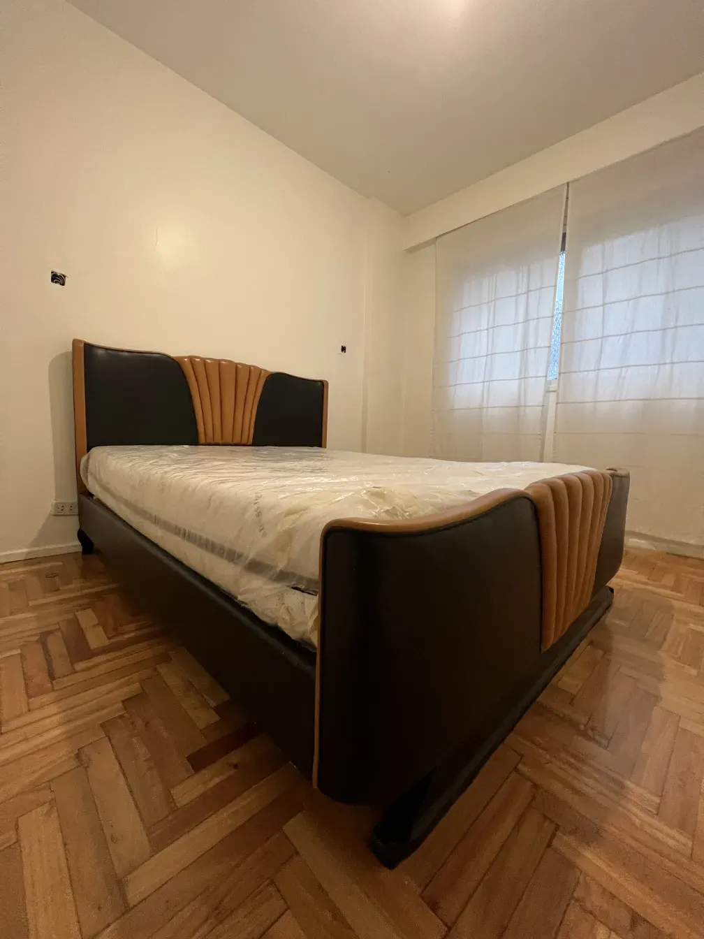 Antique bed in art deco style with decorative headboard.