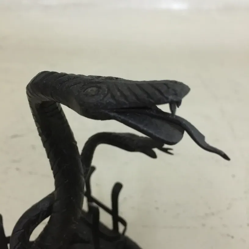 Antico vassoio per carte nero con serpente decorativo.