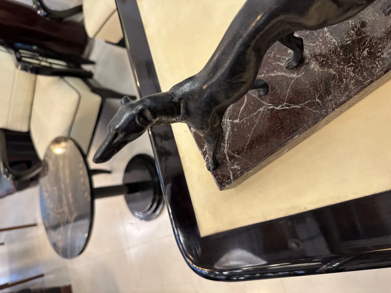 Escultura de perro en un aprieta libros antiguo con fondo de muebles