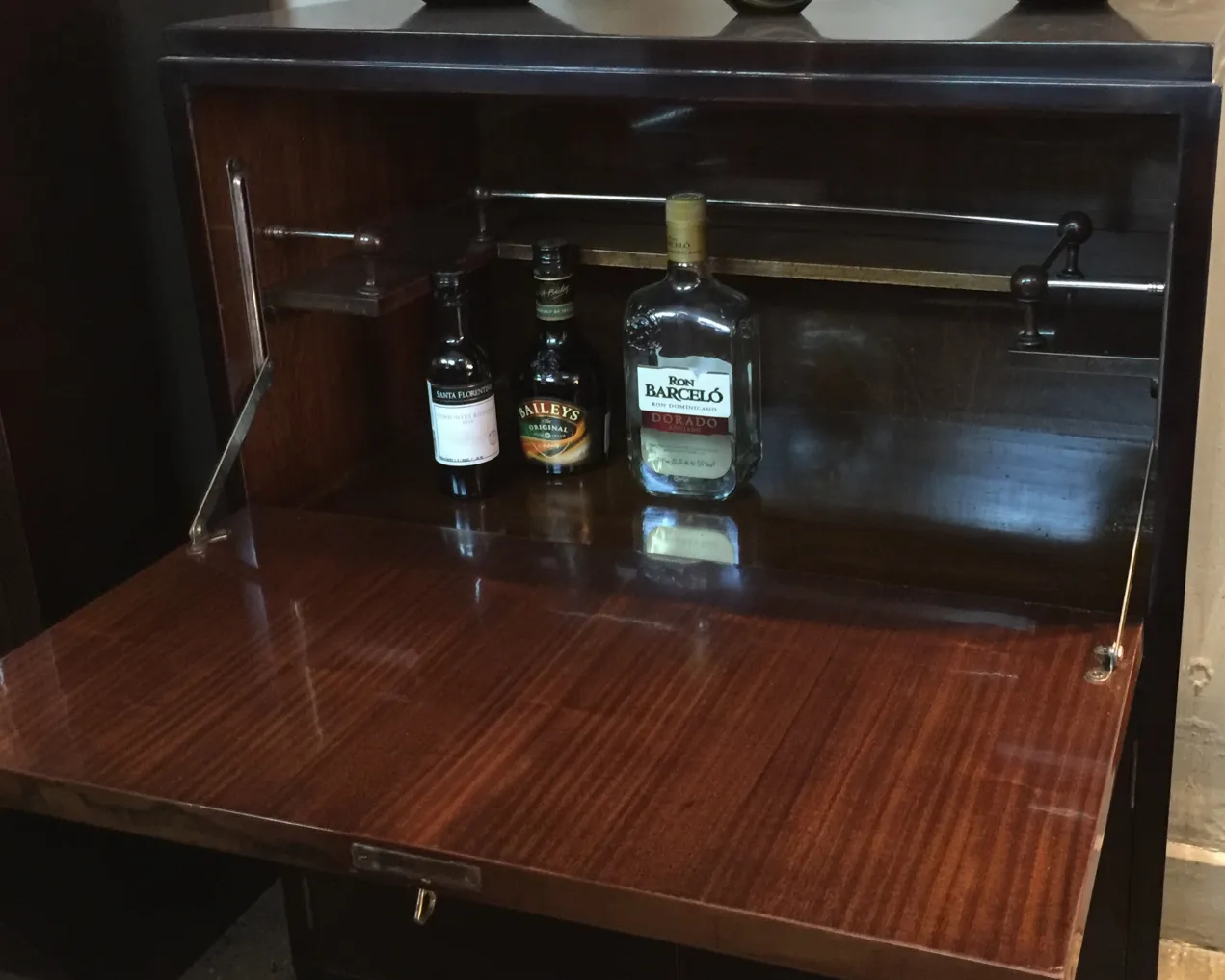 Meuble à cocktail ancien en bois avec des bouteilles à l'intérieur